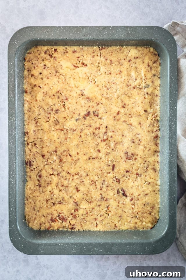 overhead view of a buttery, nutty crust evenly pressed into the bottom of a 9x13 inch baking pan.