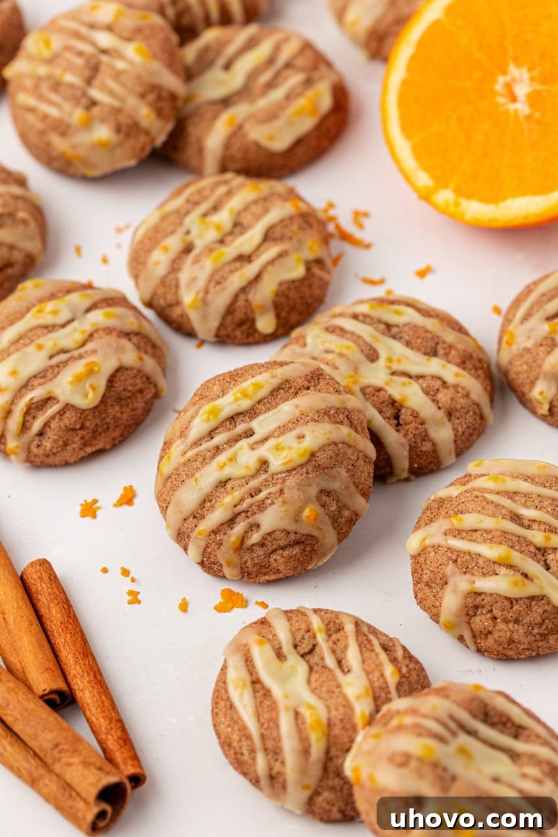 sugar and spice cookies topped with orange glaze, scattered on a white surface