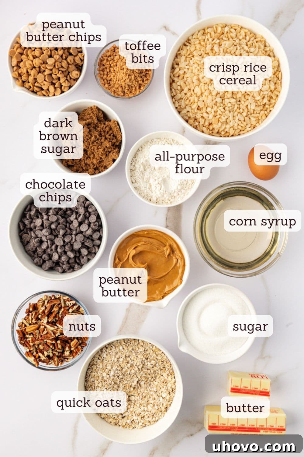 Overhead view of various ingredients laid out for making chocolate peanut butter cereal bars, including oats, sugars, flour, peanut butter, and chocolate chips.