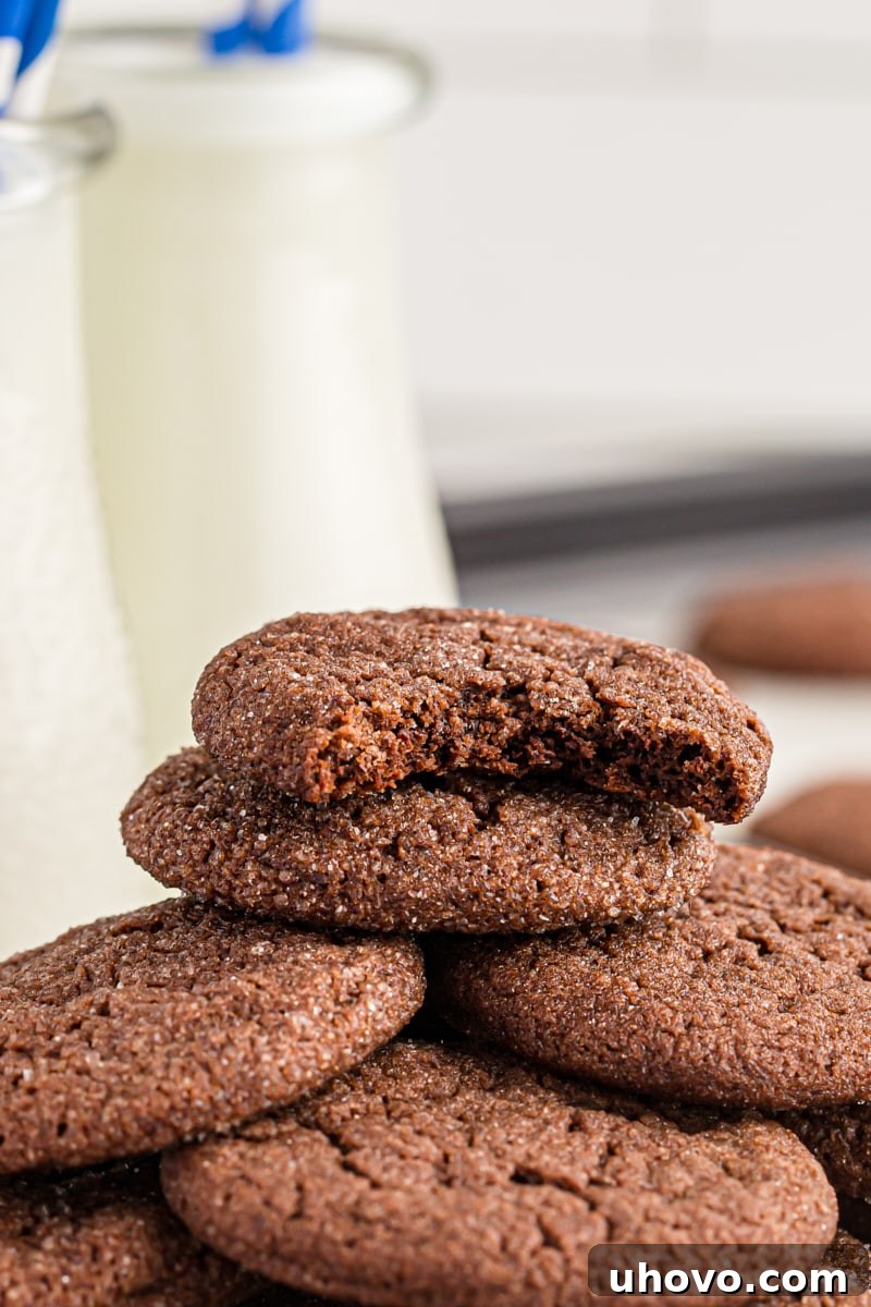 Stack of Double Chocolate Brownie Cookies next to milk jugs, emphasizing their perfect pairing with milk