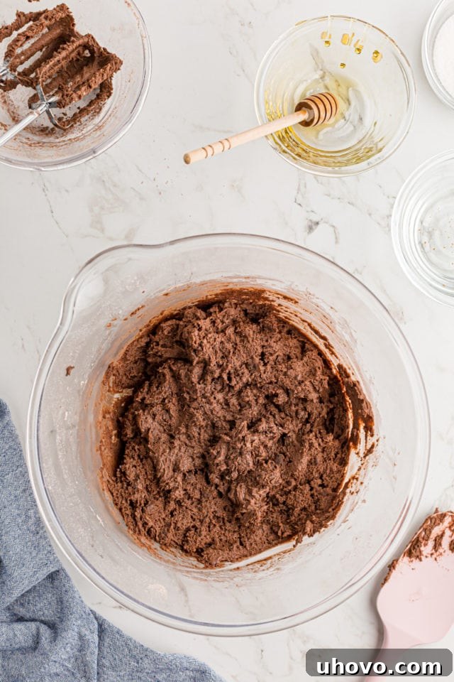 Overhead view of brownie cookie dough in a mixing bowl, ready for chilling