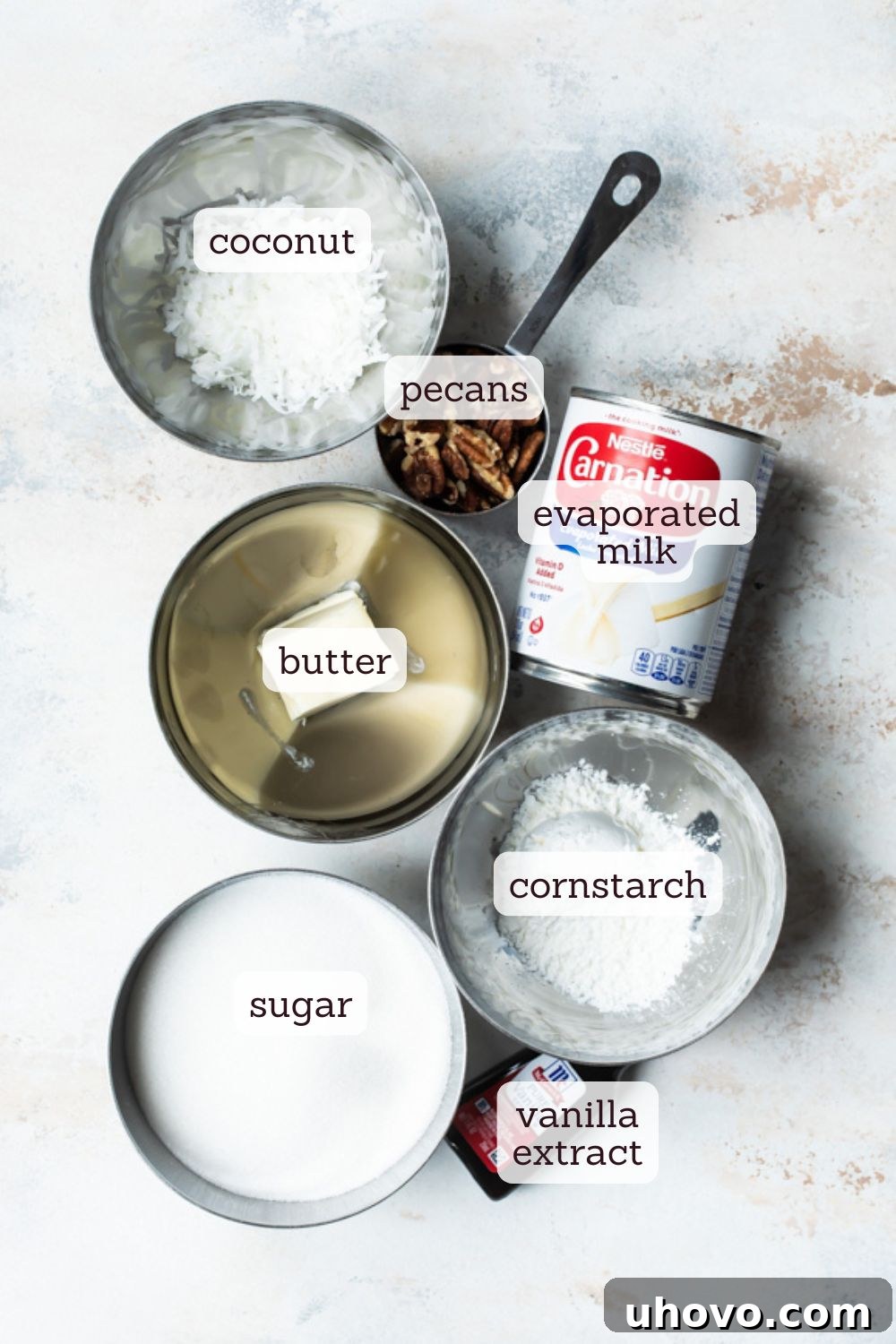 An inviting overhead shot of ingredients laid out for the rich coconut pecan sauce for German chocolate cake, featuring evaporated milk, sugar, cornstarch, butter, chopped pecans, and shredded coconut.