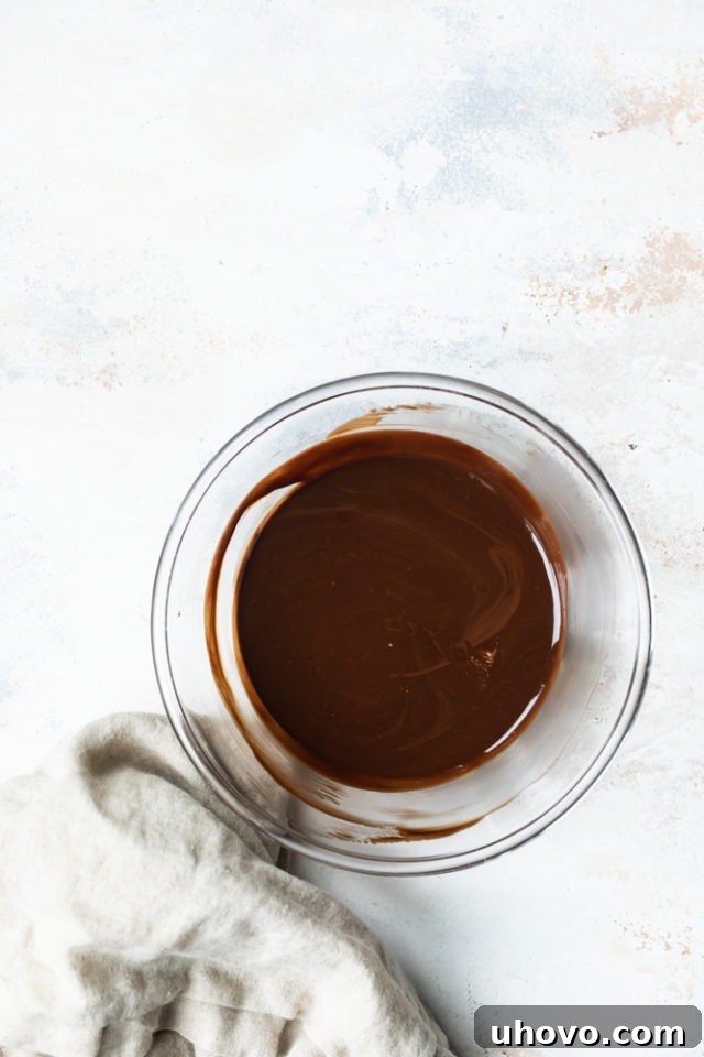 Melted butter and chocolate swirled together in a clear glass bowl, showcasing a smooth, glossy texture.