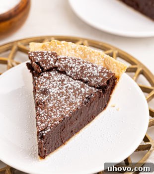 a slice of hot fudge pie with a sprinkling of confectioners' sugar on top