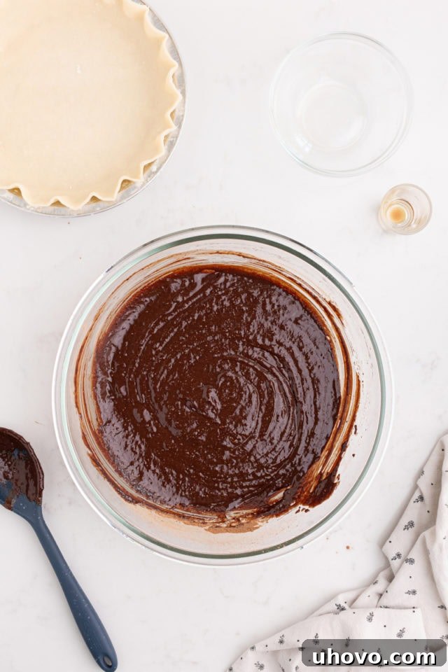 overhead view of the smooth, dark brown hot fudge pie filling in a mixing bowl, ready for the crust