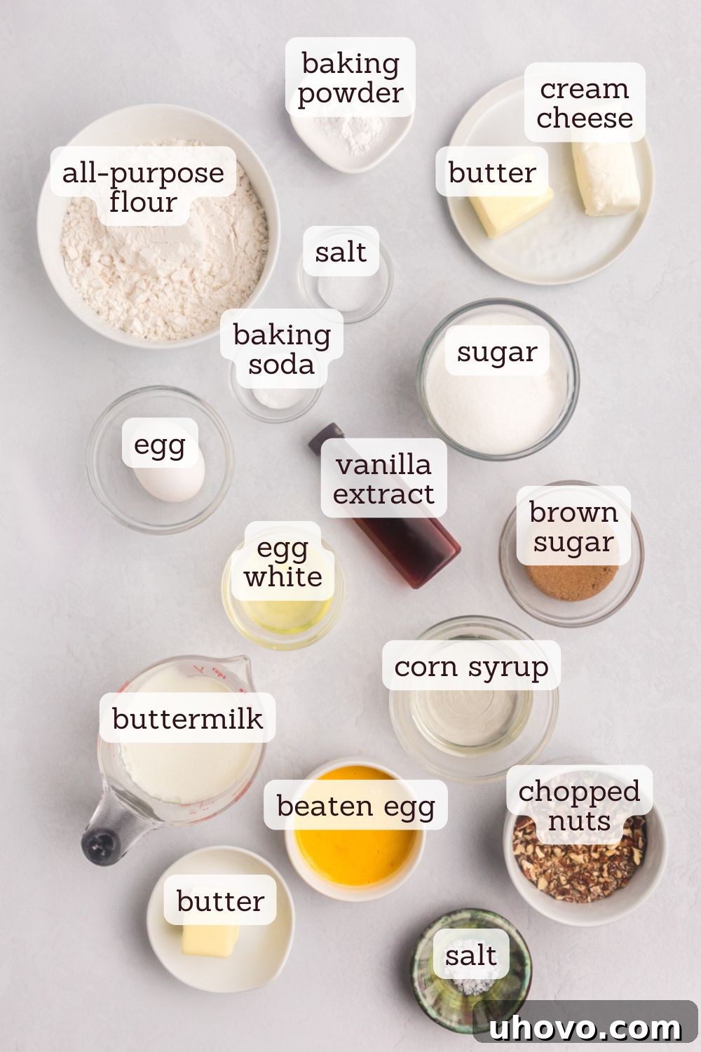 Overhead view showcasing a selection of key ingredients for Pecan Pie Coffee Cake laid out on a surface, including butter, cream cheese, flour, sugar, and buttermilk, ready for baking.