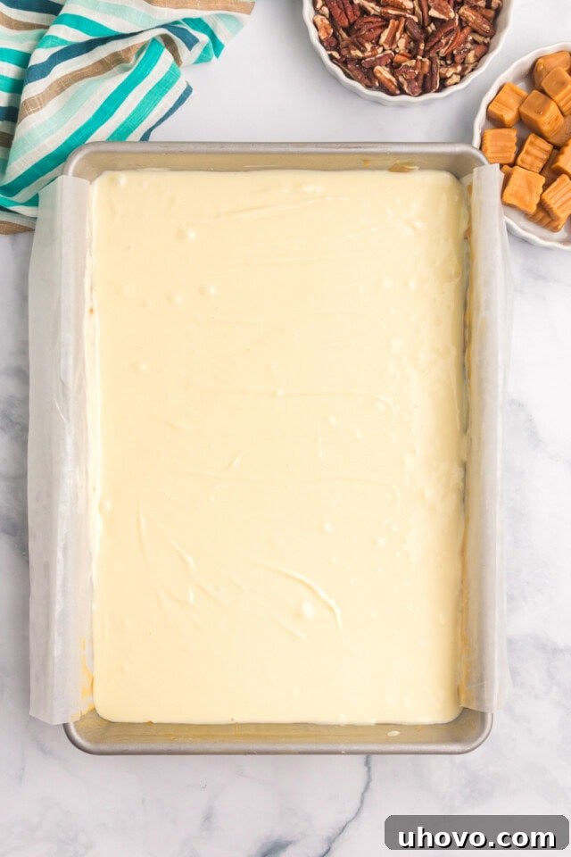 overhead view of cheesecake filling spread over caramel layer and shortbread crust