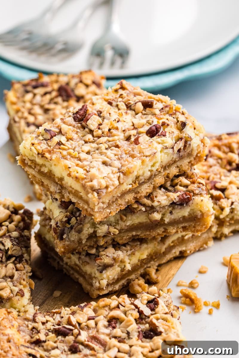stack of three layered cheesecake bars with caramel and toffee topping 