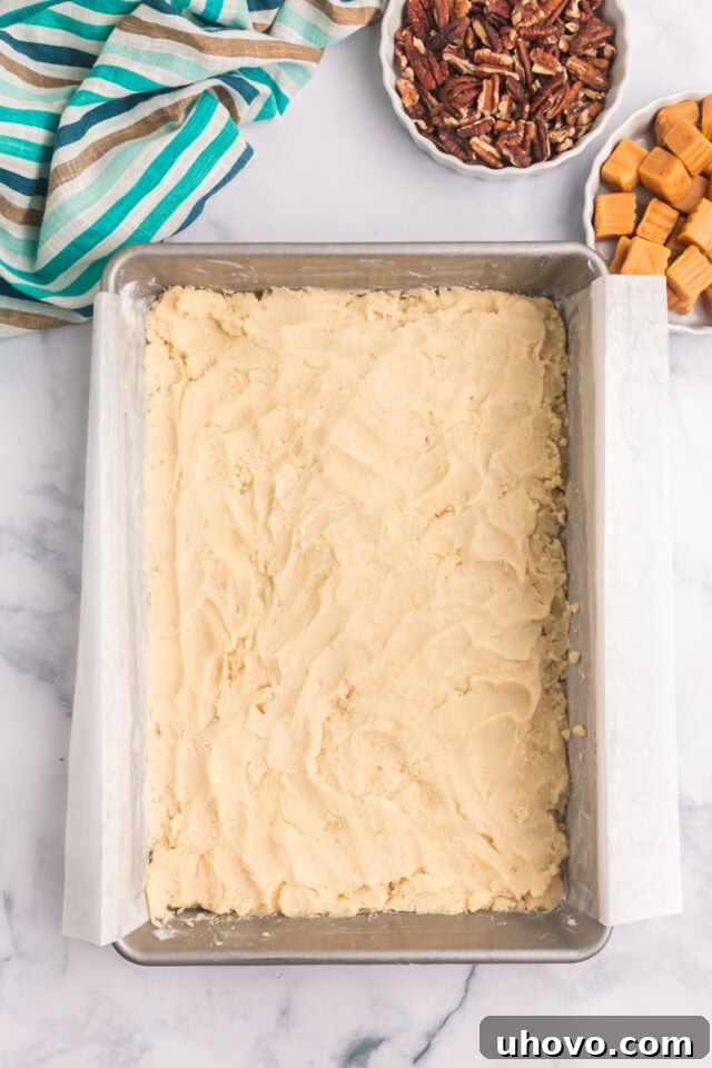 overhead view of buttery shortbread crust pressed into a 9x13 baking pan