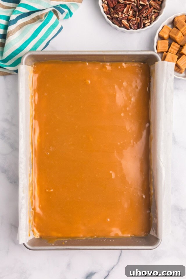 overhead view of caramel  layer spread over buttery crust for caramel cheesecake bars