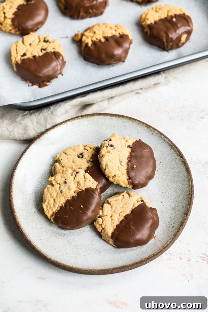 Peanut butter meltaway cookies partially dipped in chocolate and arranged on a plate.