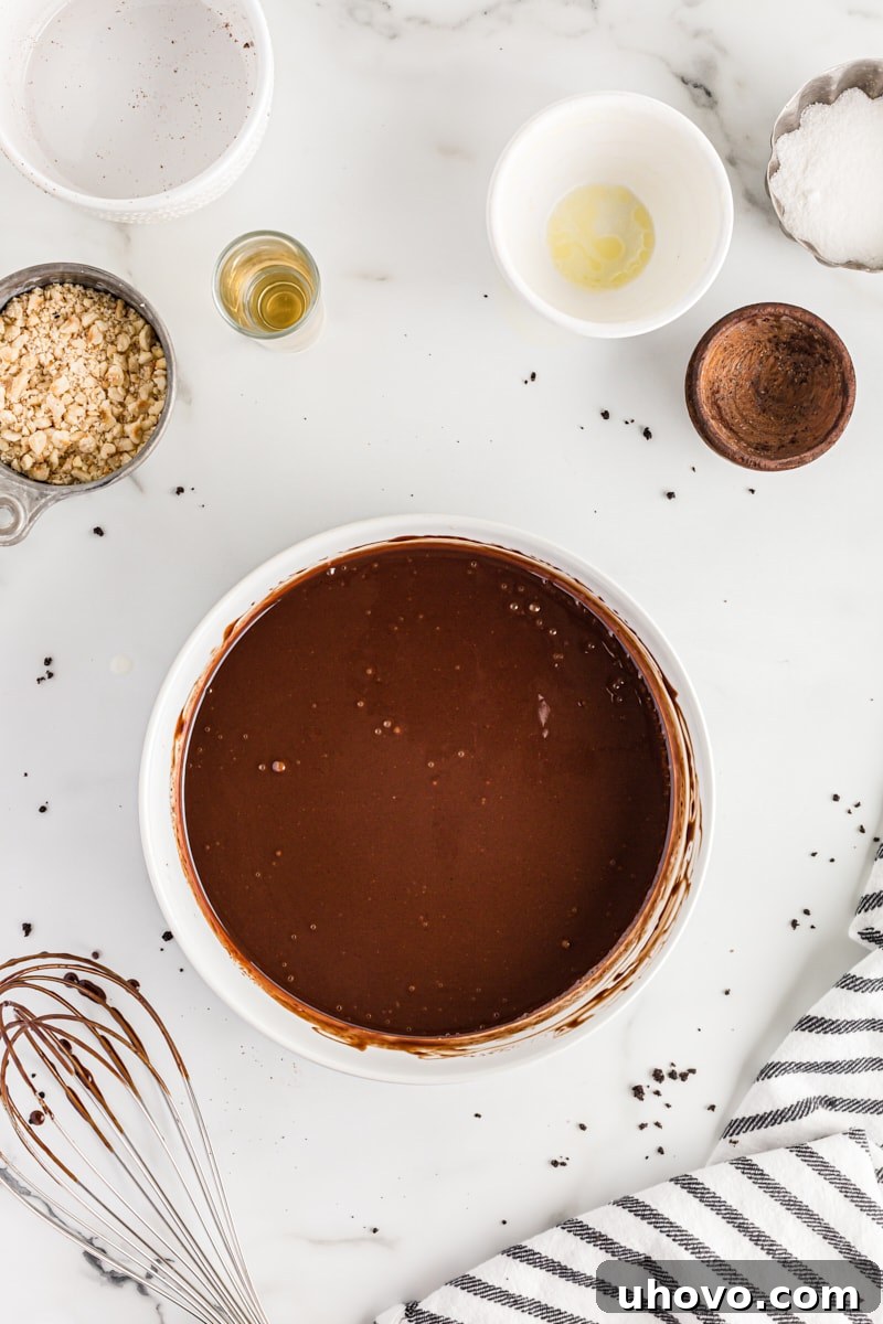Overhead view of rich, smooth chocolate ganache in a bowl after whisking, ready for the next step.