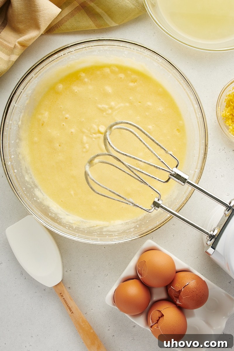 overhead view of butter, sugar, and eggs mixed in a glass mixing bowl