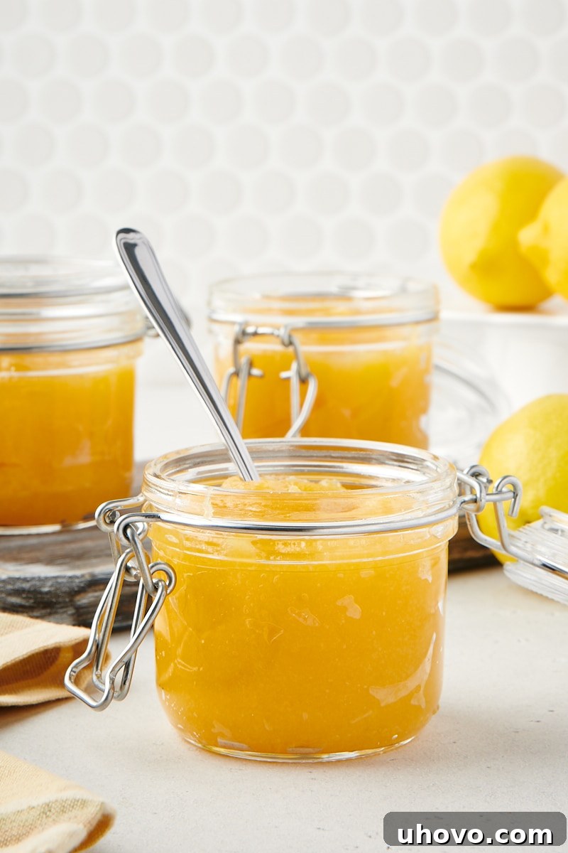 small glass jar of lemon curd with a spoon