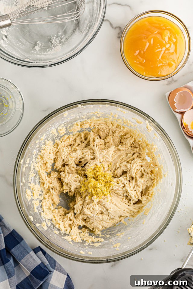 Overhead view of lemon zest added to bowl of cake batter