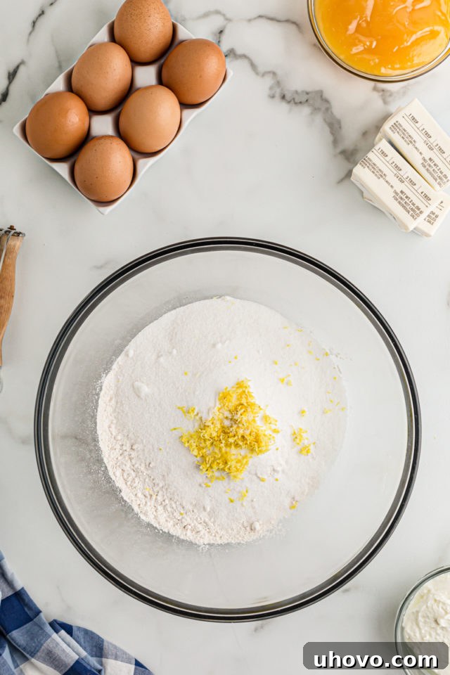 Overhead view of flour, sugar, and lemon zest in bowl