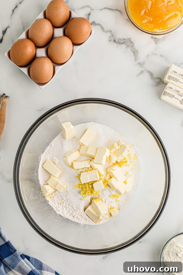 Overhead view of butter, lemon zest, and sugar in glass bowl