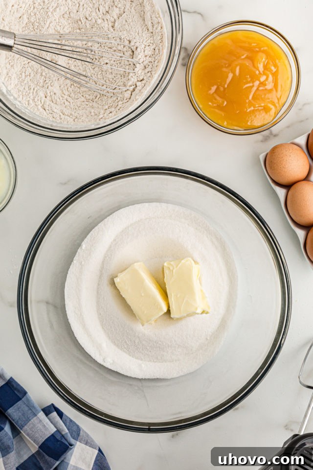 Overhead view of butter and sugar in glass mixing bowl