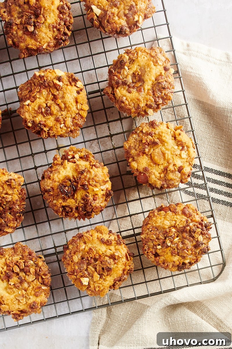 Overhead view of a batch of freshly baked granola yogurt muffins cooling on a wire rack, steam gently rising.