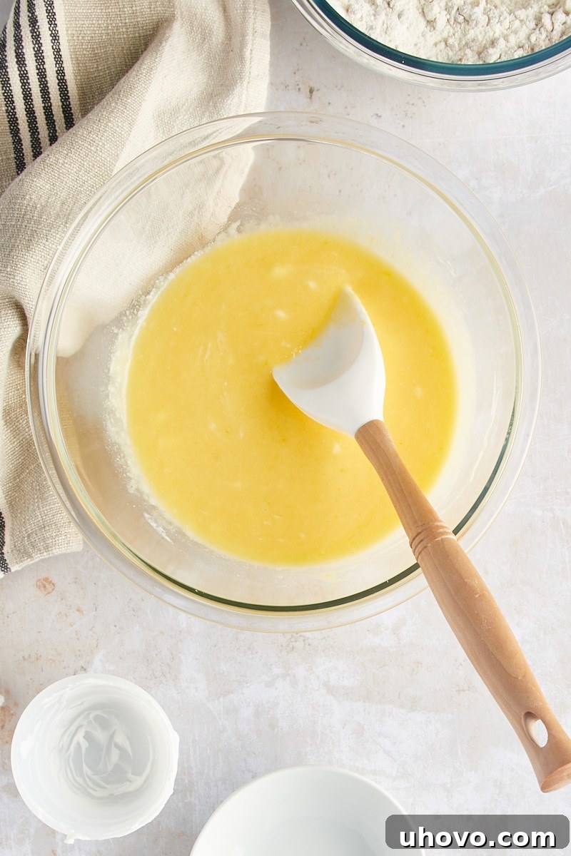An overhead shot revealing the wet ingredients for muffins smoothly combined in a mixing bowl.