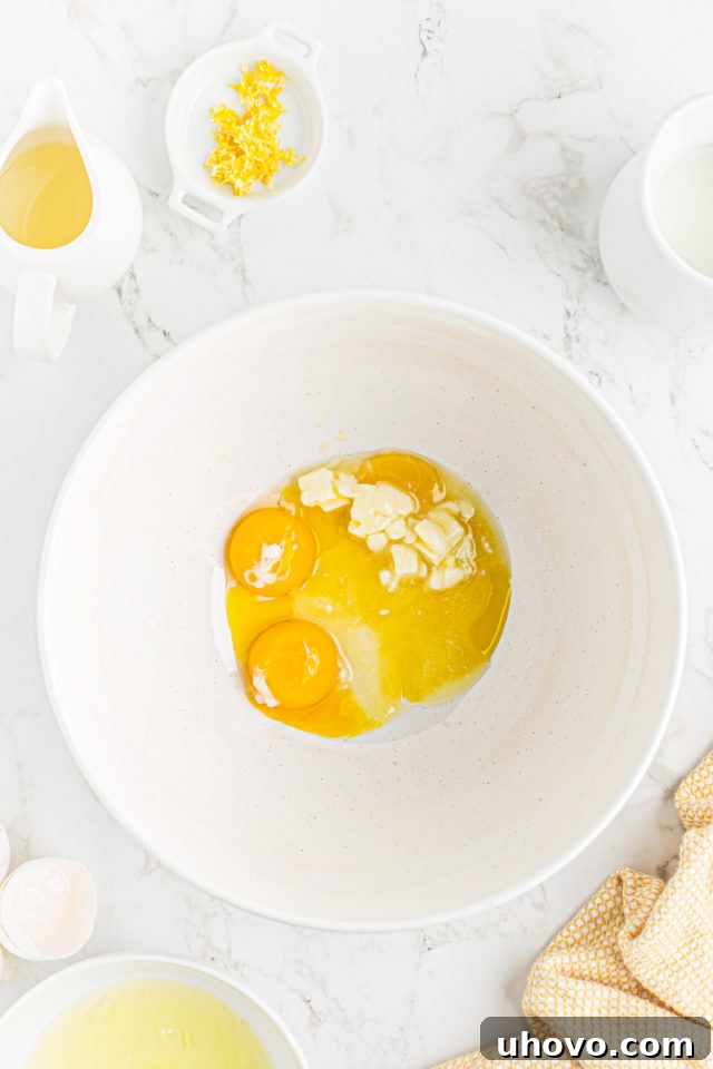 Egg yolks and softened unsalted butter combined in a separate mixing bowl, ready for blending.