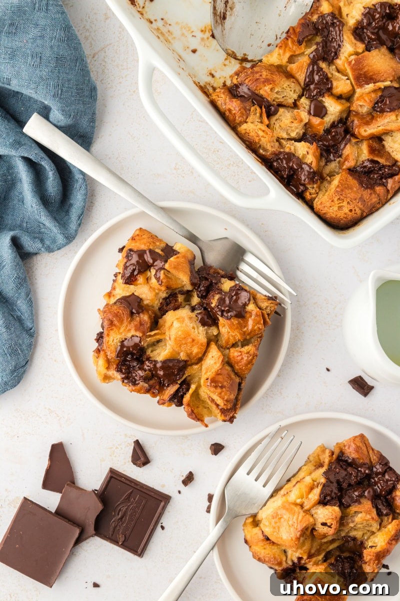 Overhead view of two plates of chocolate croissant bread pudding with forks, ready to eat