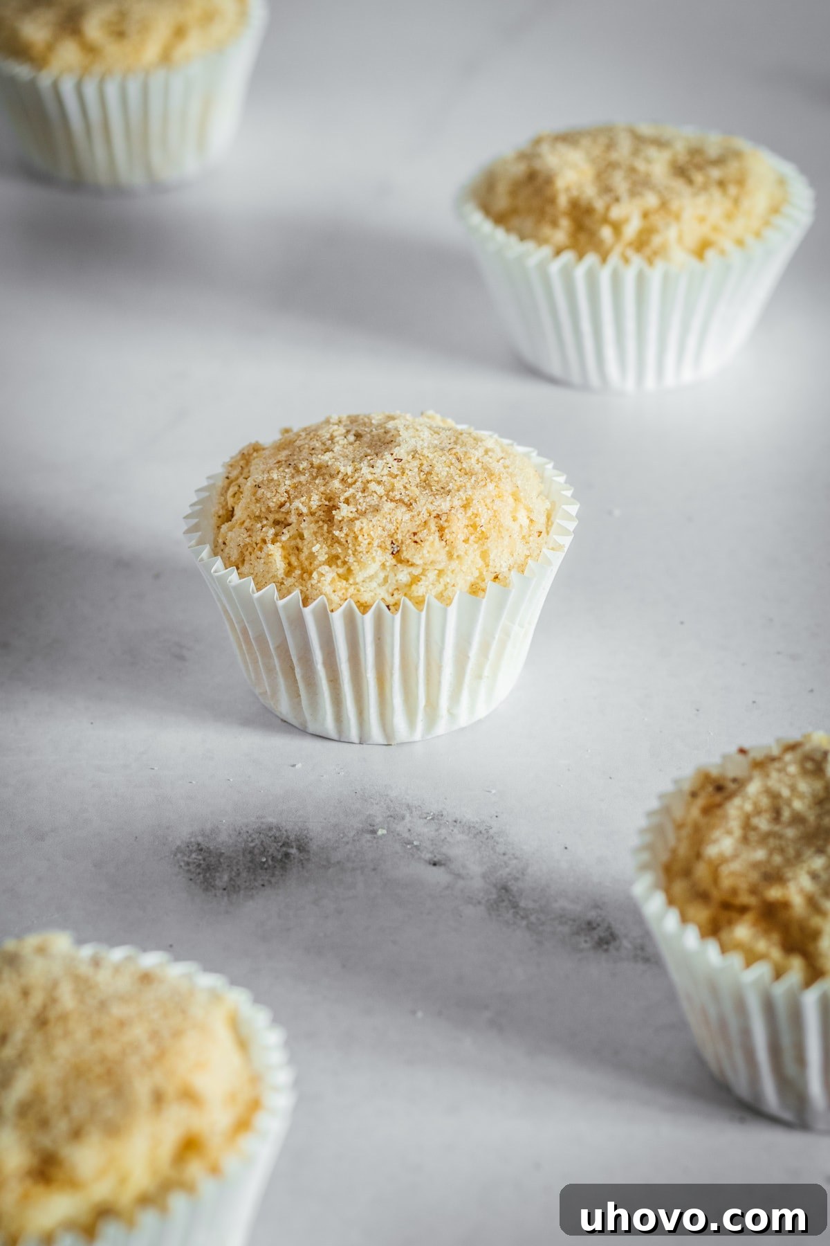 A cluster of cream cheese muffins nestled in their paper liners, presented beautifully on a marble slab.