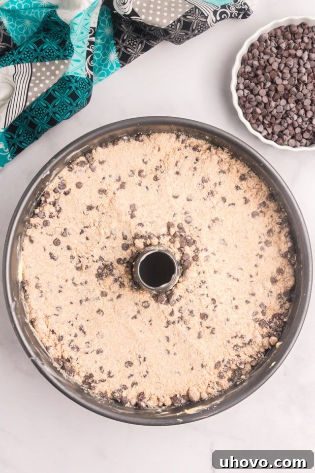 An enticing overhead shot of the chocolate chip crumb pound cake nestled in a tube pan, adorned with its final layer of crumb mixture, ready to be baked to golden perfection.