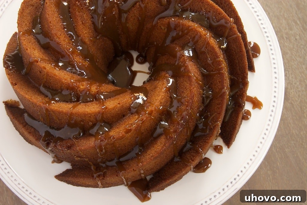 A beautifully baked Brown Sugar Bundt Cake, golden brown and glistening with a promise of rich, moist flavor. The elegant fluted design stands out beautifully.