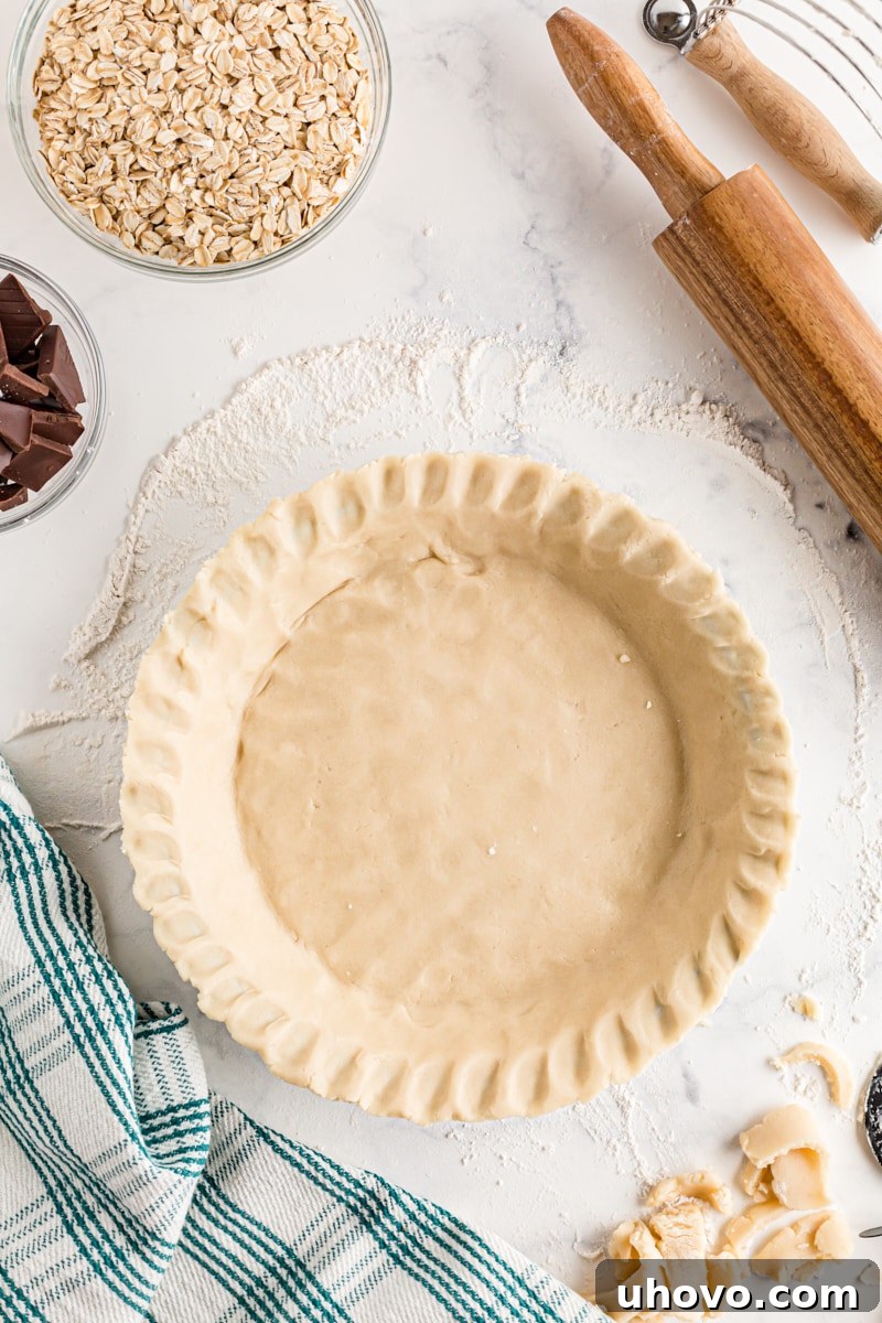 A pie crust nestled perfectly in a pie pan, with decorative crimped edges.
