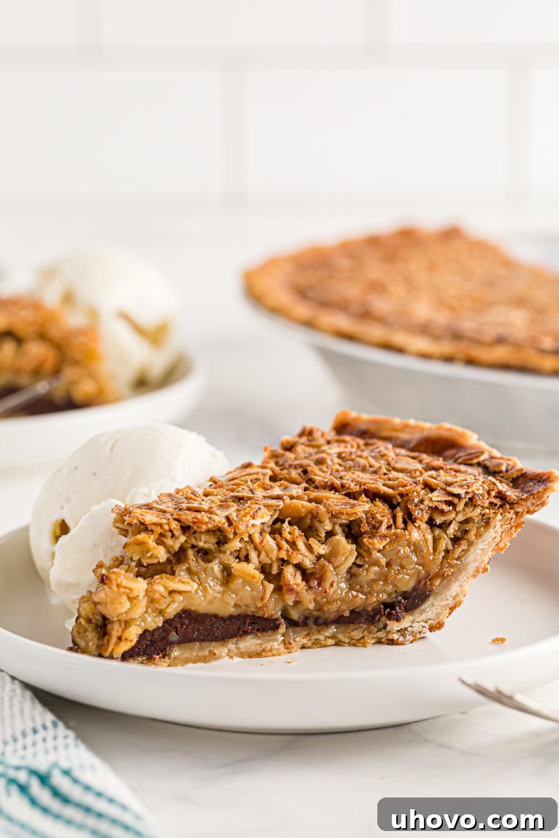 A side-view of a slice of oatmeal pie, clearly showing the distinct chocolate ganache layer underneath the oat filling.