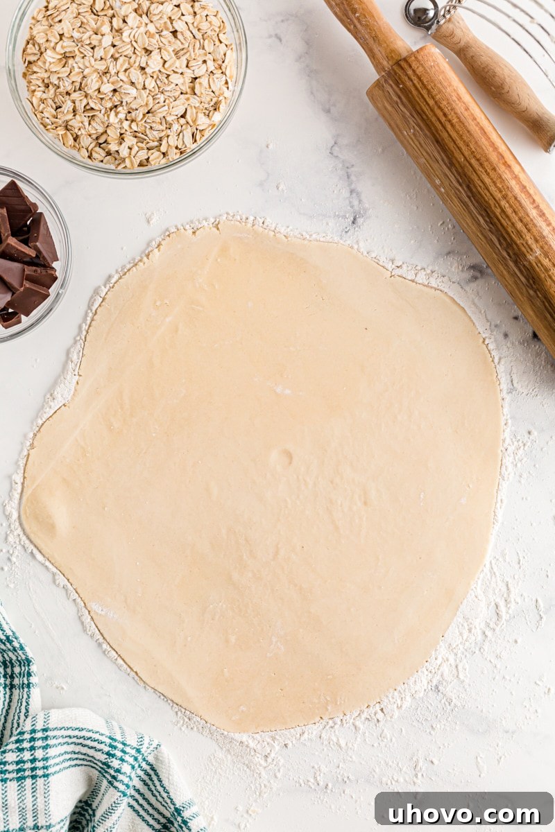 A pie crust dough neatly rolled out into a circle on a lightly floured countertop.