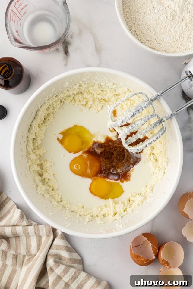 Vanilla, eggs, and milk added to the creamed butter and sugar mixture