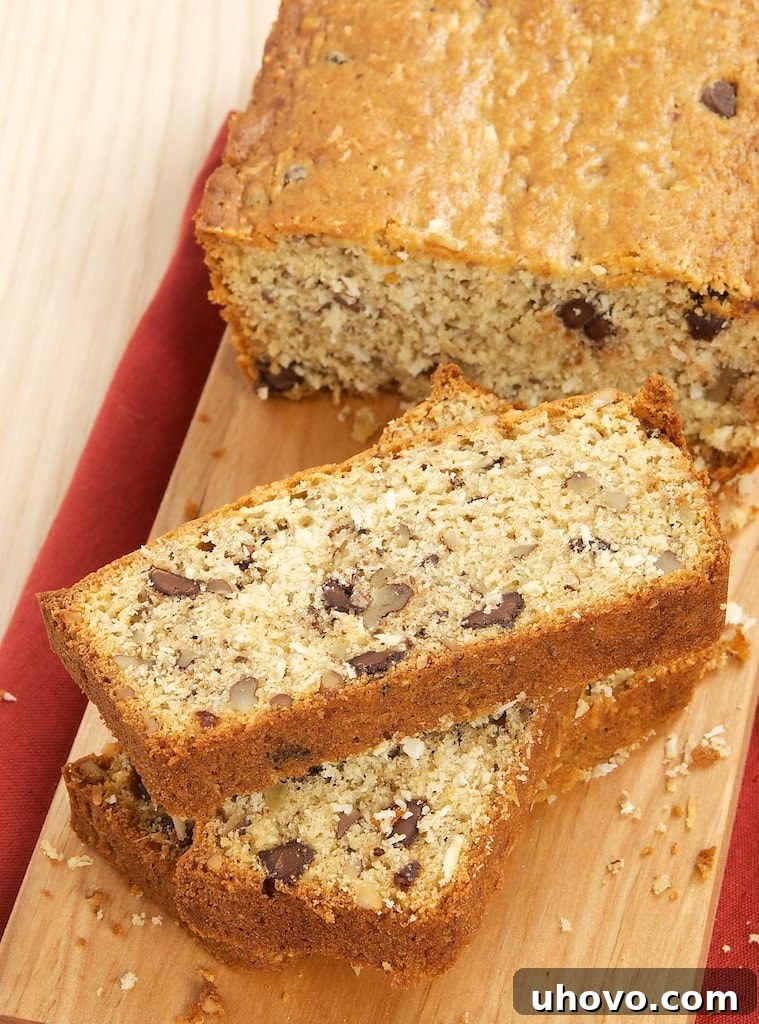 A slice of Chocolate, Coconut, and Pecan Bread on a small plate with a fork, ready for a delightful breakfast or snack, showcasing the gooey chocolate and textured coconut.