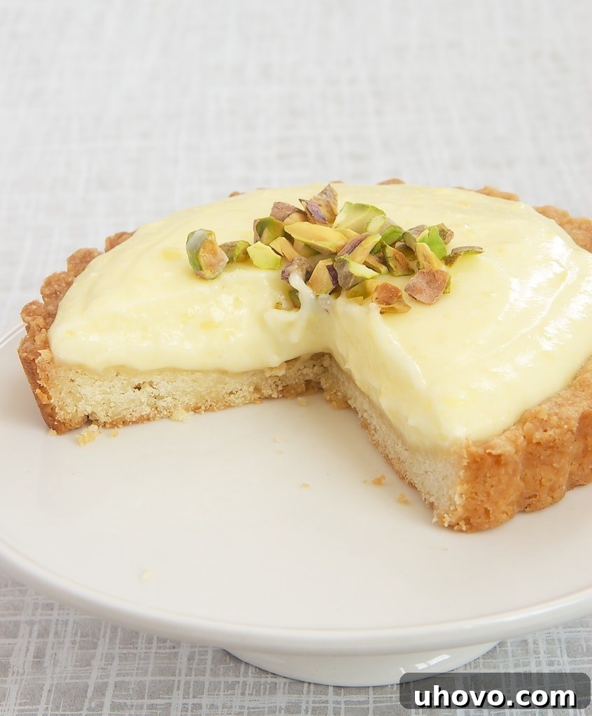 A slice removed from a Lemon Cream Tart, revealing the creamy filling and crisp crust
