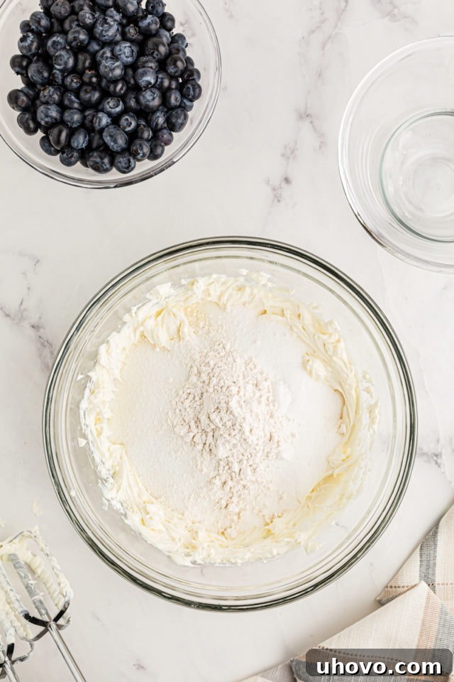 Overhead view of dry ingredients added to beaten cream cheese