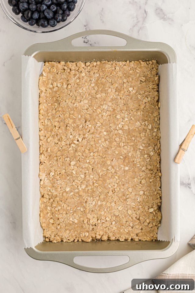 Overhead view of crust for cheesecake bars in pan