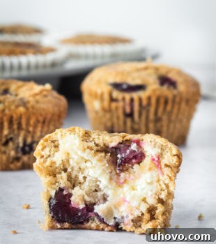 A Cherry Cheesecake Muffin cut in half to show the cream cheese filling inside.
