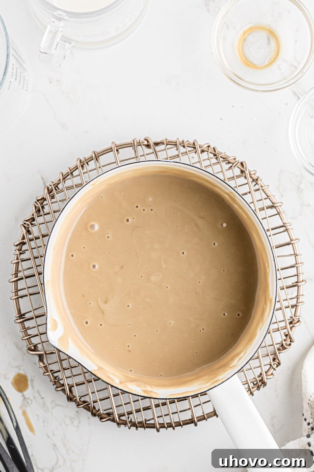 The finished butterscotch pudding, smooth and golden, resting in the saucepan after the final ingredients have been incorporated.