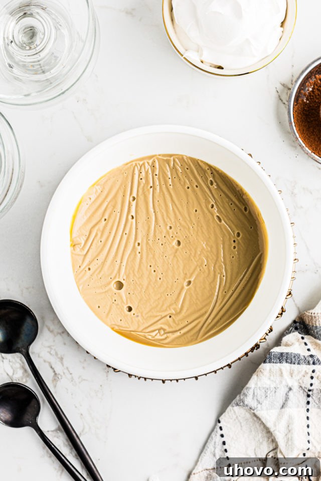 A single serving of butterscotch pudding, perfectly chilled and ready to be garnished, showcased in a small glass bowl.