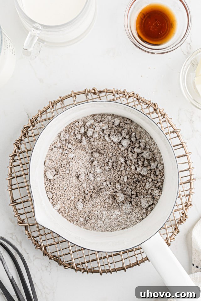 A close-up view of the dry ingredients for butterscotch pudding thoroughly whisked together in a saucepan.