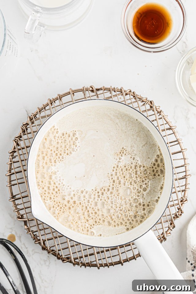 An overhead shot showing the liquid ingredients smoothly blended with the dry mix in the saucepan, forming the base of the pudding.