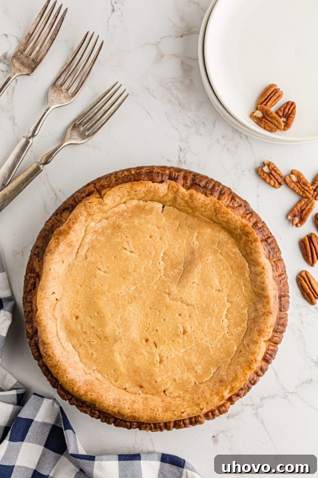 The fully assembled Pecan Pie Cheesecake, freshly baked and golden, cooling in its springform pan.