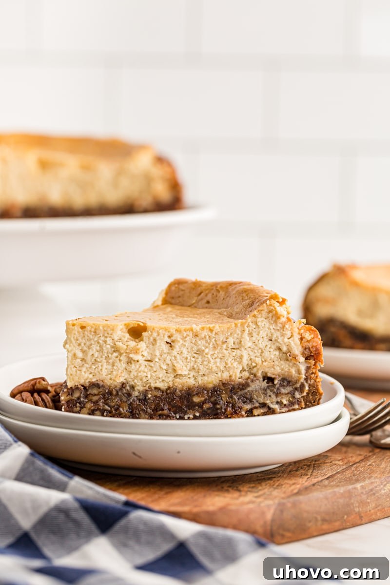 A pristine slice of pecan pie cheesecake served elegantly on a simple white plate, ready for dessert.