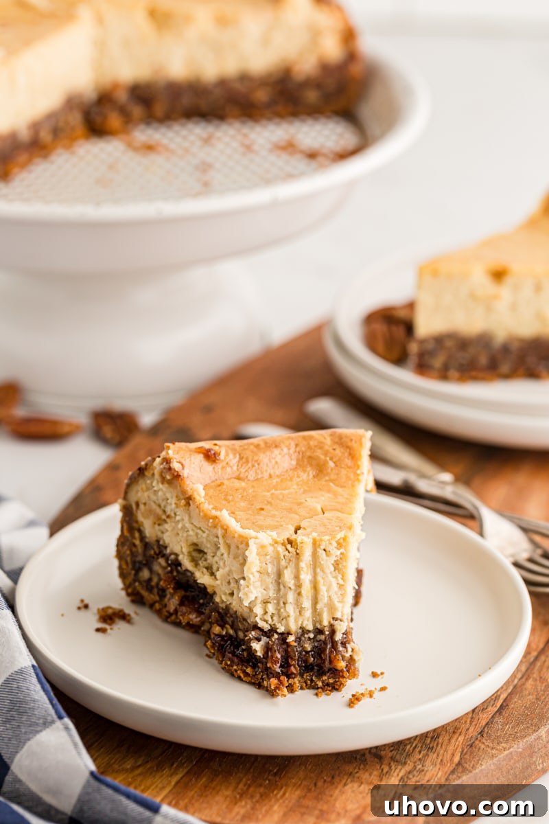 A slice of pecan pie cheesecake with a bite taken out, showing the perfectly balanced layers and inviting texture.