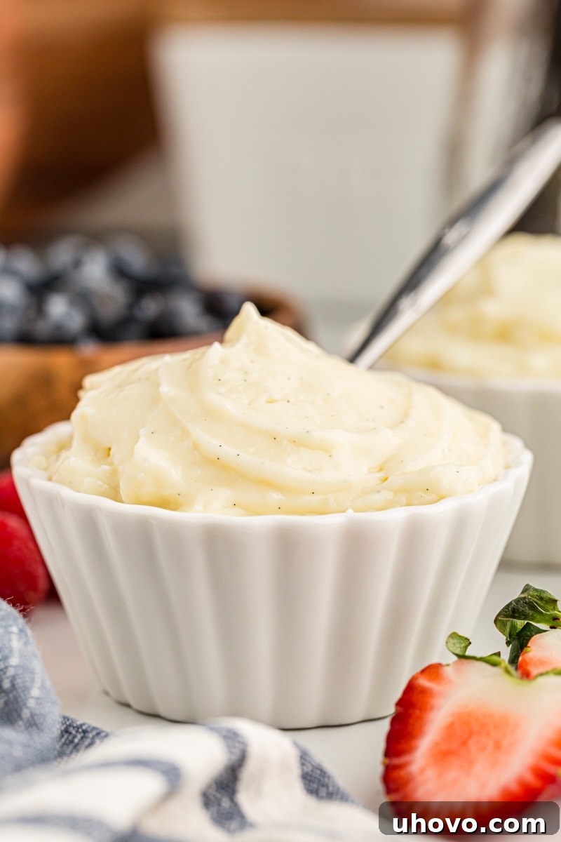 A creamy homemade vanilla pudding presented in a pristine white custard cup, with a spoon resting beside it, inviting a taste.