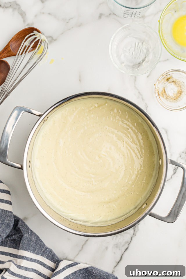 Overhead view of beautifully cooked vanilla pudding smoothly coating the inside of a pan, indicating a perfect, lump-free texture.
