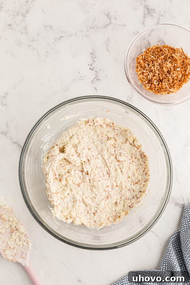 Overhead view of pudding mixed with toasted coconut in mixing bowl