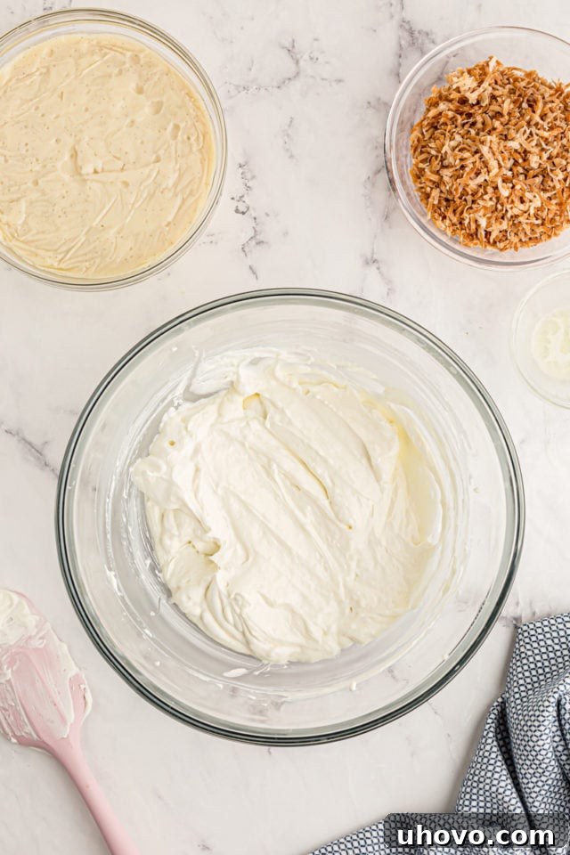 Overhead view of cream cheese mixture, vanilla pudding, and toasted coconut in bowls