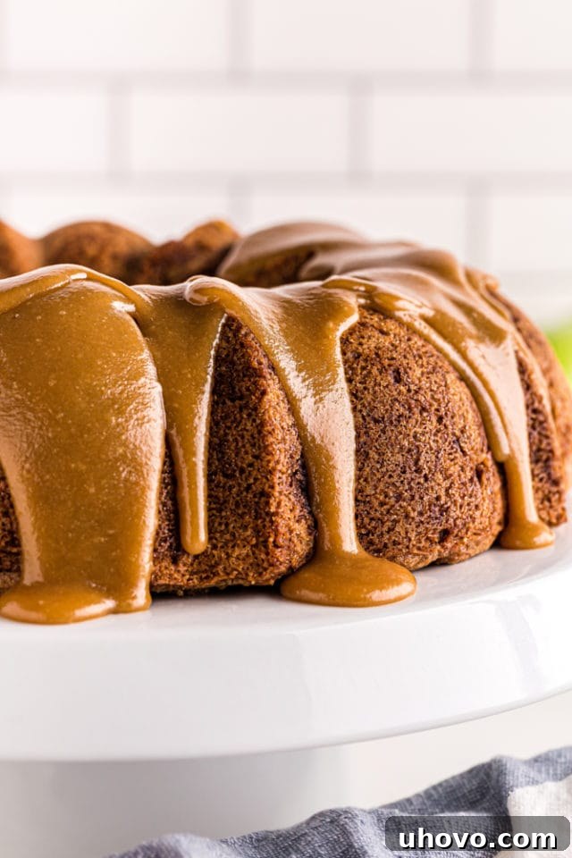 caramel-glazed Apple Spice Cake on a white cake stand